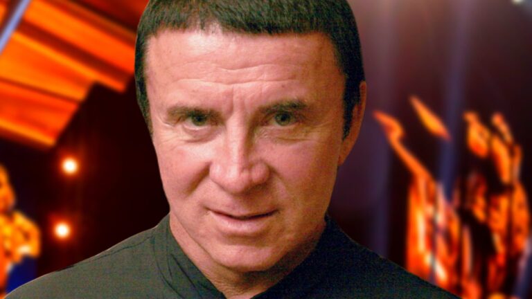 Анатолий Кашпировский крупным планом на фоне сцены и огненных эффектов, спорная фигура психотерапии и телецелительства